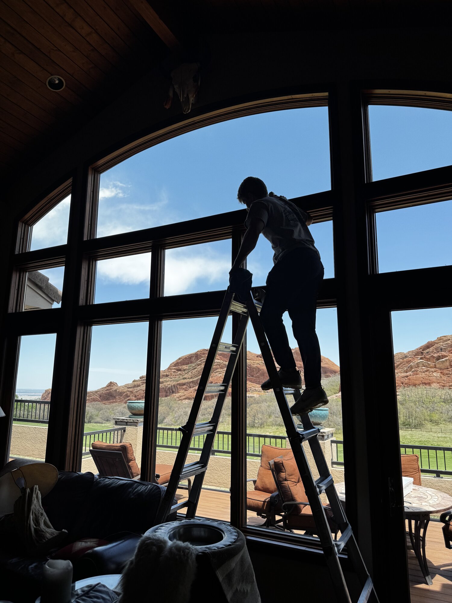 Crystal-clear arched picture window with mountain view after cleaning